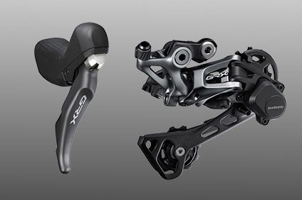 Shimano GRX bike shifter and derailer on gray background
