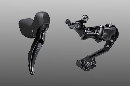 Shimano GRX RX400 shifter and derailleur set against gray background