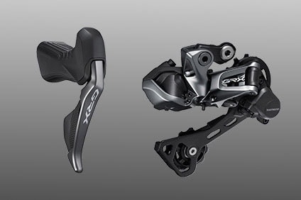 Shimano GRX bike shifter and derailleur on a gray background