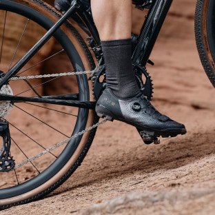 Close-up of cyclist's foot on a bike pedal on rough terrain