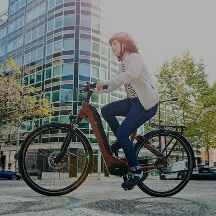 Person riding a Shimano Nexus bicycle in an urban environment on a sunny day