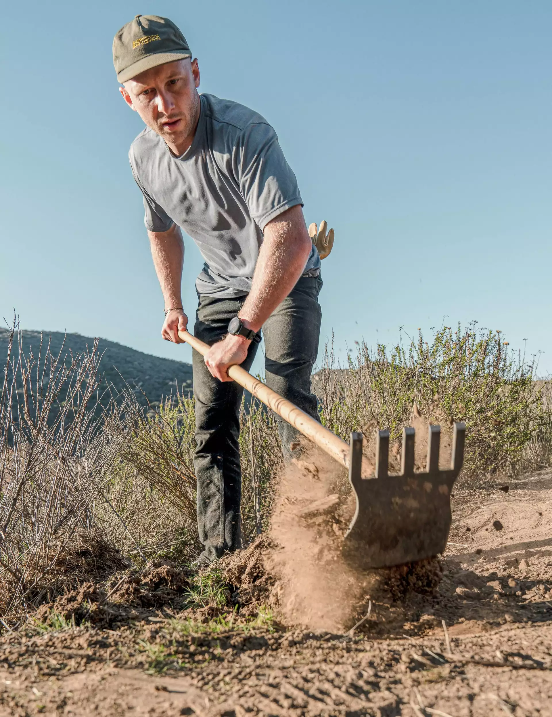 Stiarbeider som bruker et redskap til å rydde en terrengsykkelsti