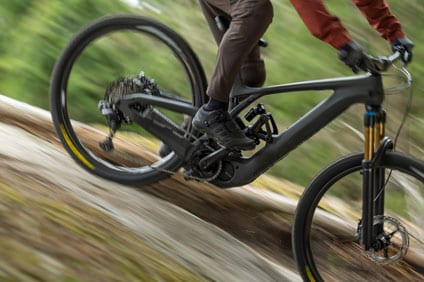 Person riding a mountain bike down a trail with motion blur