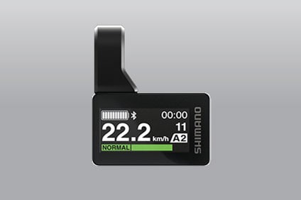 Schermo del ciclocomputer Shimano che mostra una velocità di 22,2 km/h e altri parametri su sfondo grigio.