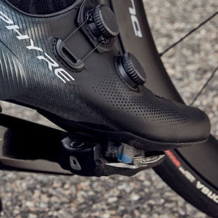 Close-up of a cyclist's shoe clipped into a pedal on a bicycle