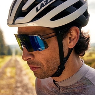 Cyclist wearing a helmet and sunglasses riding on a forest trail