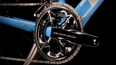 Close-up of a Dura-Ace bicycle crankset and chainring on a blue bike frame