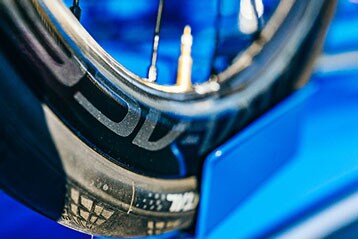 Gros plan d'une roue de vélo avec un fond bleu.
