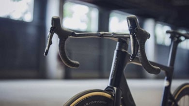 Gros plan du guidon et de la roue d’un vélo de route dans un environnement faiblement éclairé.