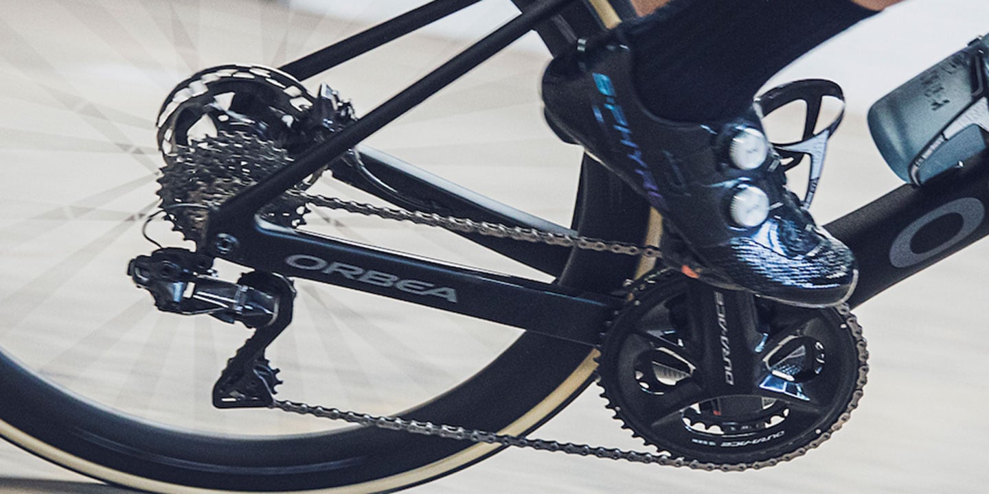 Close-up of cyclist pedaling an Orbea bike with Dura-Ace components on a smooth roadroad