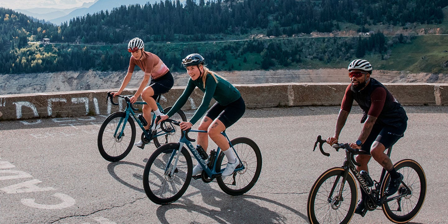 Group of cyclists riding on a mountain road with scenic background