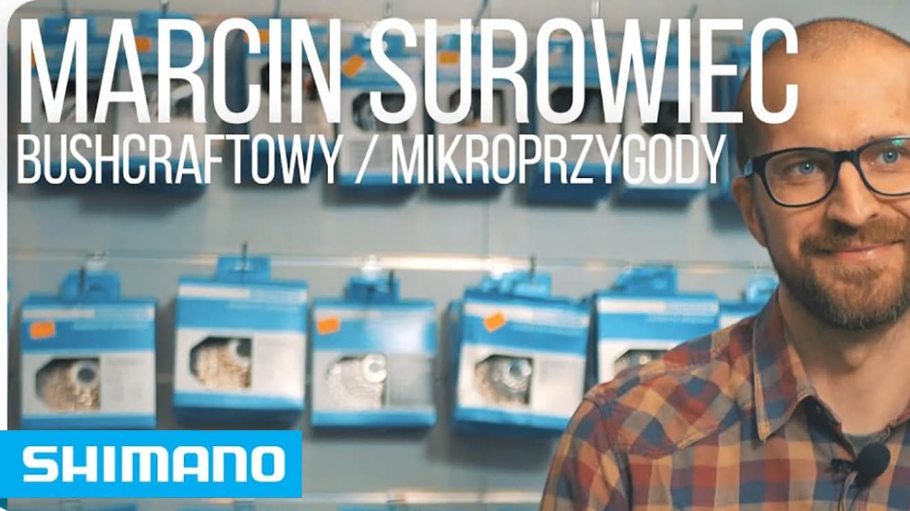 Mężczyzna w koszuli w kratę na tle ekspozycji produktów Shimano.