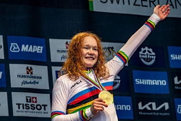 Cyclist celebrating with a gold medal on stage