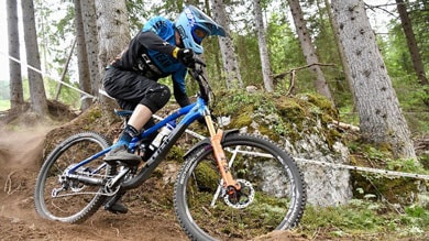 Mountainbiker rast durch einen Waldpfad.
