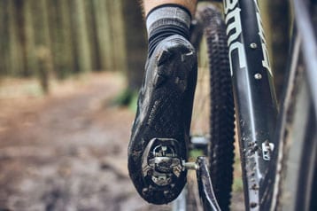 Nahaufnahme eines Fahrradschuhs, der in ein Pedal auf einem Trail eingeklickt ist