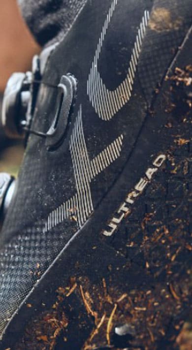 Nahaufnahme eines schlammigen Fahrradschuhs in einem Waldgebiet