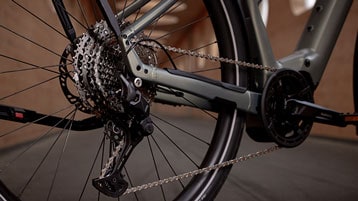 Close-up of a bicycle rear derailleur and gears in an indoor setting