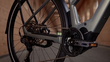 Close-up view of a bicycle drivetrain and rear wheel in an indoor setting.