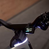 Close-up of a bicycle handlebar with an electronic display showing speed and distance