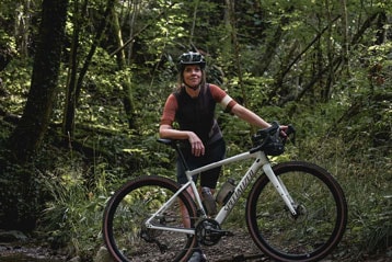 Radfahrer mit Fahrrad in einer Waldumgebung.