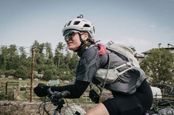 Radfahrer mit Helm und Rucksack fährt im Freien.