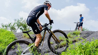 Two cyclists mountain biking on rocky terrain