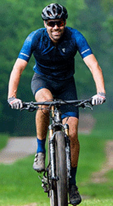 Two cyclists riding on a forest trail