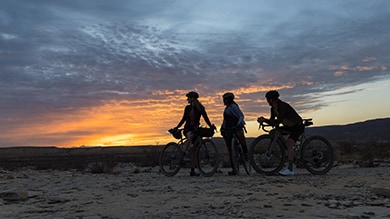 Gravel cyclist taking a break to watch the sunset in the Arizon desert