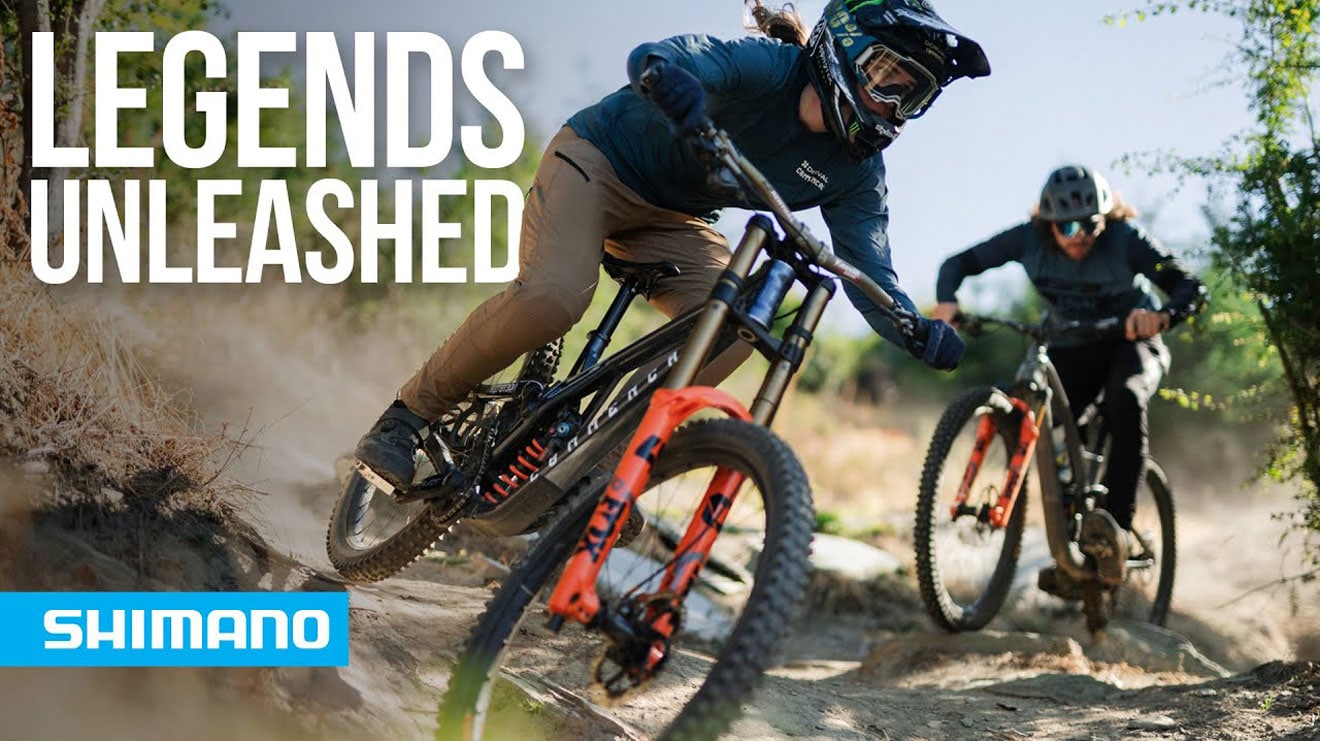 Mountain bikers riding down a trail with text Legends Unleashed and Shimano logo