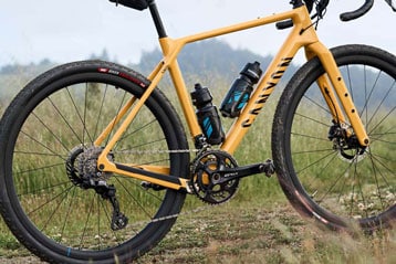 Gelbes Canyon-Rennrad mit Trinkflaschen, Seitenansicht.