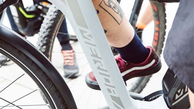 Close-up of person with tattoo on leg, riding a Merida bicycle.