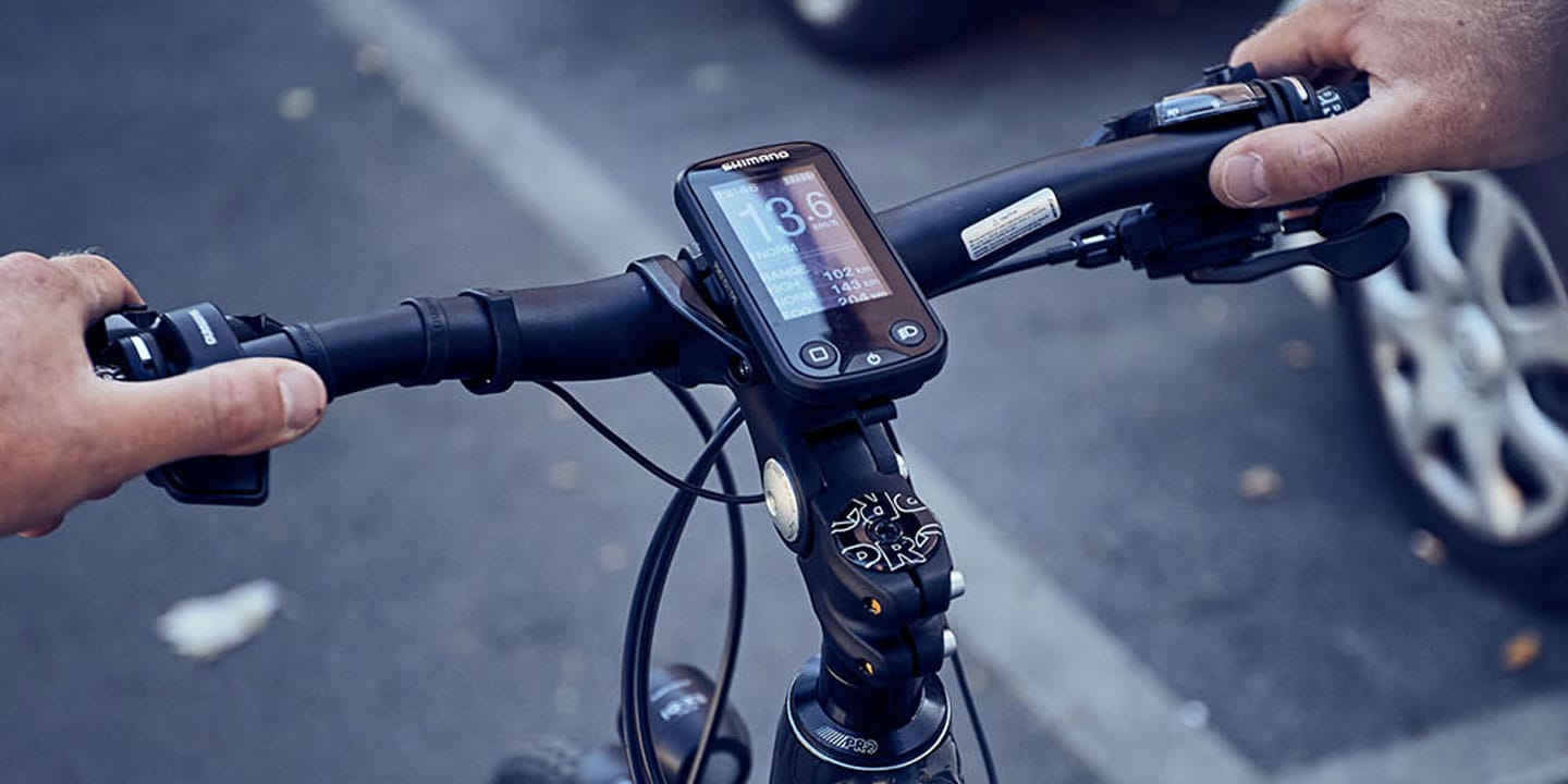 Close-up of a bicycle handlebar with a digital display showing speed and distance