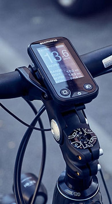 Close-up of a bicycle handlebar with a digital display showing speed and distance