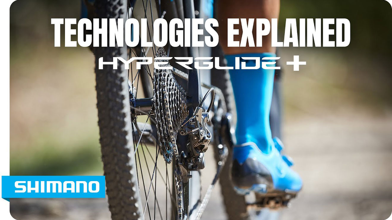 Technologies Explained Hyperglide Plus by Shimano banner with close-up of bike chain and rider's blue shoes