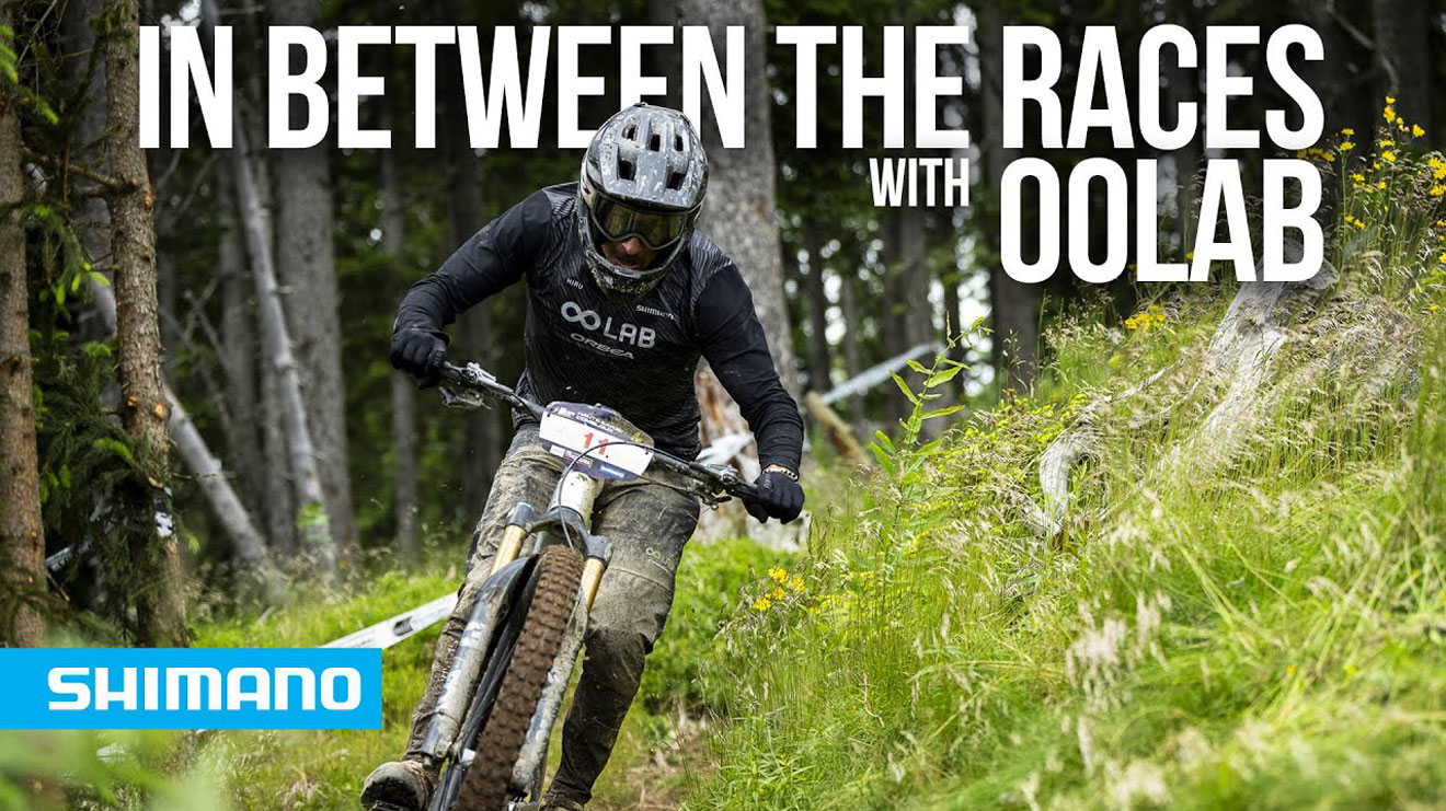 Mountain biker racing through a forest trail with 'Shimano' logo and text overlay.