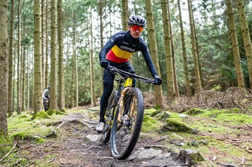 Fietser rijdt op een mountainbike over een bospad.