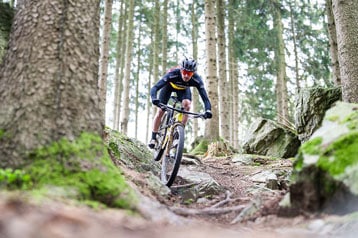Mountainbiker navigeert een rotsachtig bospad.