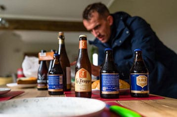 Man op de achtergrond met verschillende speciaalbieren op een tafel.