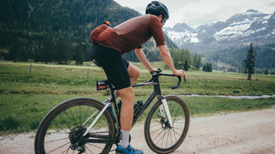 Radfahrer fährt in einer malerischen Berglandschaft.
