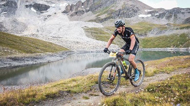 Radfahrer bei einem Mountainbike-Rennen nahe einem alpinen See