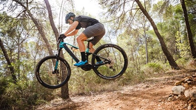 Mountainbiker springt auf einem Waldweg