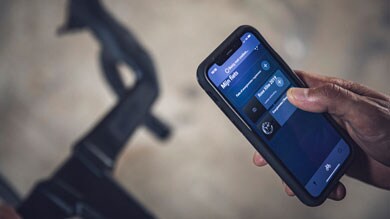 Persona sosteniendo un smartphone con la interfaz de una app de ciclismo.