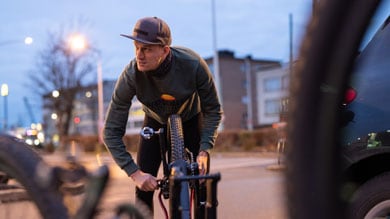 Persoon stelt een fietswiel af in de buitenlucht.