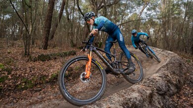 Mountainbikers racen over een bospad.
