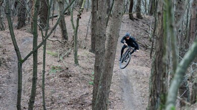 Mountainbiker rijdt over een bospad.