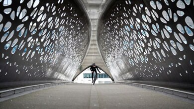 Fietser rijdt door een tunnel met geometrische patronen.