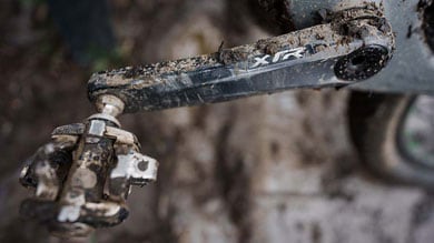Modderige fietstrapas en pedaal.