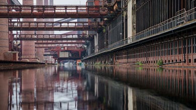 Industriële waterweg met fabrieksgebouwen en leidingen.
