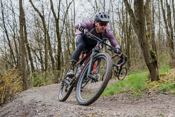 Fietsers rijden over een onverhard bospad.