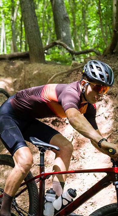 Twee fietsers rijden op mountainbikes over een bospad.